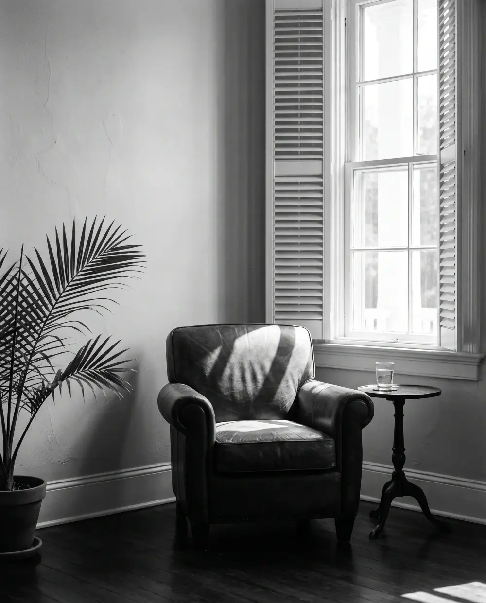 A leather chair beside a shuttered window in a quiet office