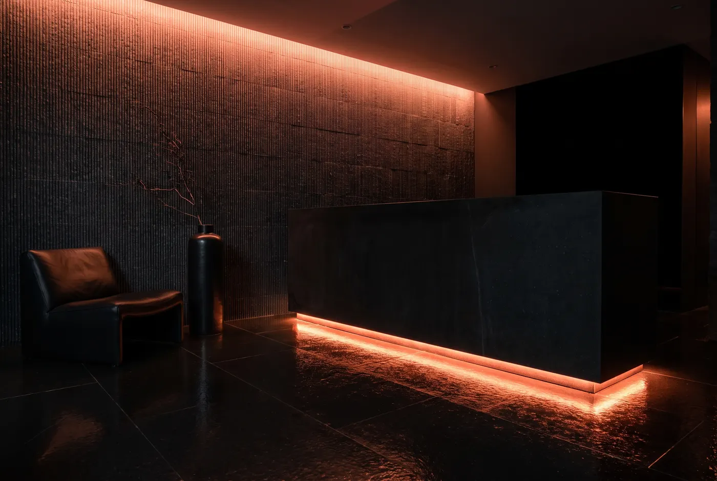 Reception at Terrane: a black basalt desk with a glowing coral light line beneath it and a ribbed stone wall