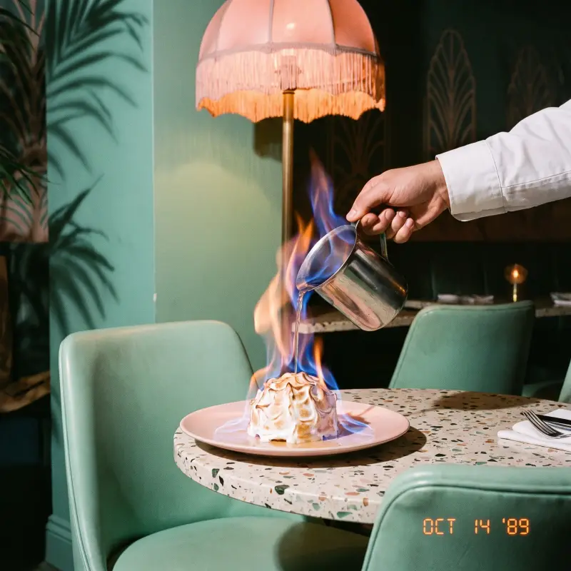 Key lime baked Alaska being flamed at the table