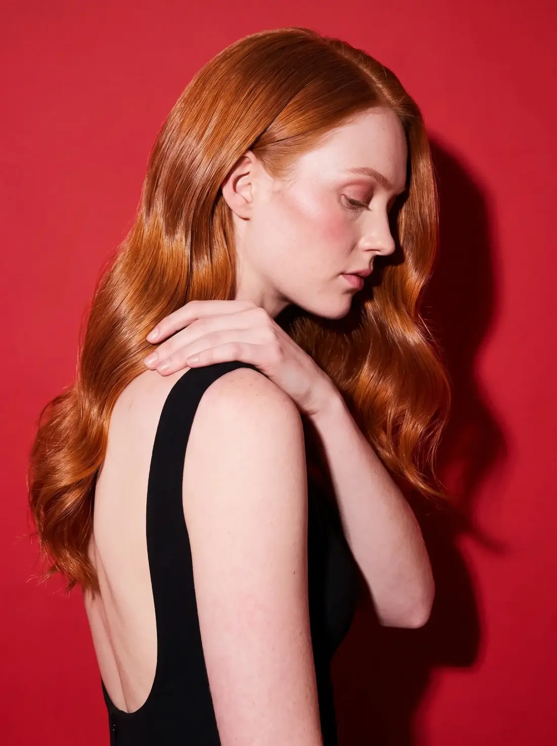 The same copper hair in profile, swept over one shoulder.